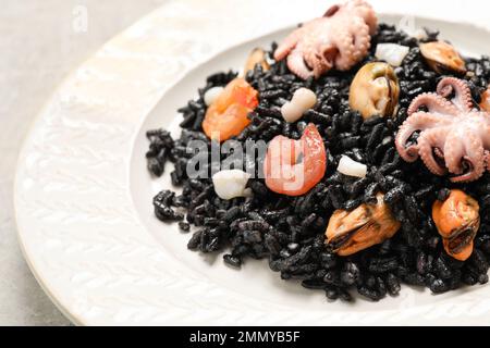 Délicieux risotto noir aux fruits de mer servis sur l'assiette, en gros plan Banque D'Images