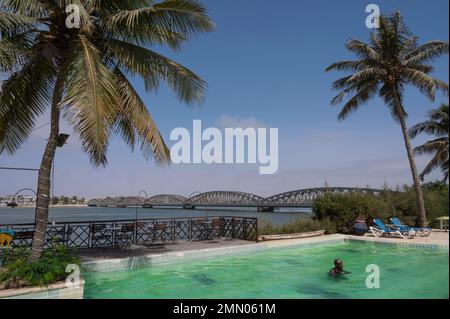 Sénégal, Saint Louis, classé au patrimoine mondial de l'UNESCO, la piscine de l'hôtel Flamingo avec le pont Faidherbe en arrière-plan Banque D'Images