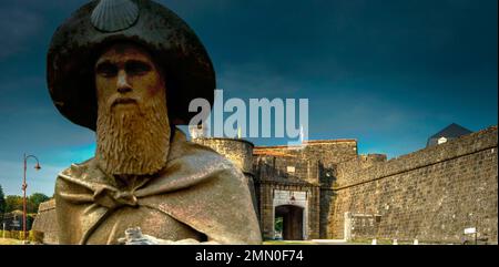 France, Pyrénées Atlantiques, Béarn, Navarrenx, sculpture d'un pèlerin sur le chemin de Saint Jacques devant les remparts d'une ville sous un ciel orageux Banque D'Images