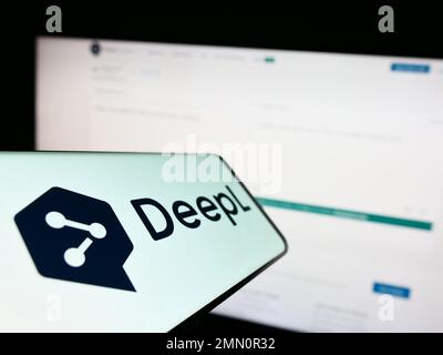 Smartphone avec logo de la machine neurale traducteur DeepL sur l'écran en face du site Web. Mise au point au centre-gauche de l'écran du téléphone. Banque D'Images