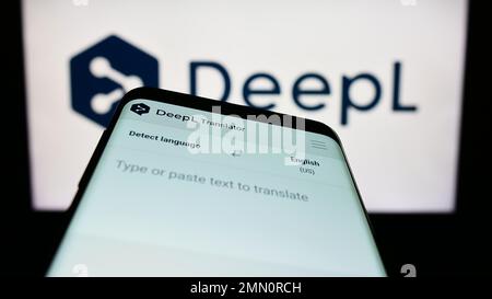 Téléphone mobile avec page web du traducteur de machine neurale DeepL à l'écran devant le logo. Faites la mise au point dans le coin supérieur gauche de l'écran du téléphone. Banque D'Images