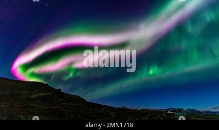 Aurore borealis faisceaux lumineux rose et vert sur le campervan Banque D'Images