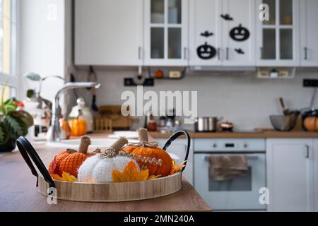 L'intérieur de la cuisine blanche de style Scandi est décoré de citrouilles pour Halloween. Ambiance automnale, décor pour les vacances Banque D'Images