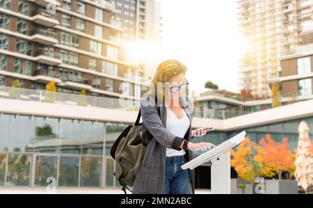 Femme utilisant l'écran numérique sur la rue de la ville. Concept Banque D'Images