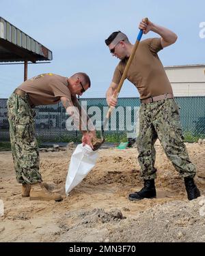 BASE AÉRIENNE NAVALE DE JACKSONVILLE, FLORIDE) Le chef de commandement principal Dustin Bryant, à gauche, de l'escadron de soutien logistique de la flotte (VR) 58, Et contrôleur de la circulation aérienne 1st classe Jonathan CICH, un chef de la sélection de petit officier affecté au Fleet Readiness Center Southeast, remplit des sacs de sable à la base aérienne navale de Jacksonville, le 27 septembre 2022, en prévision de l'arrivée de l'ouragan Ian plus tard dans la semaine. La station de remplissage est ouverte à toute personne sur la base qui a besoin de sacs pour protéger son installation ou sa résidence de base. Banque D'Images