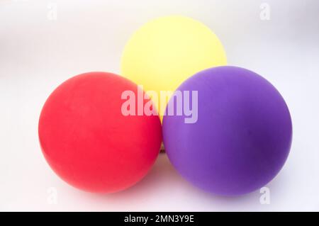 Trois ballons gonflés des couleurs rouge, jaune et violet représentent le drapeau républicain en Espagne sur un fond neutre Banque D'Images