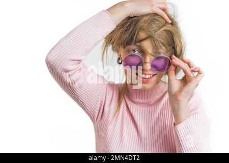Une femme gaie en lunettes de soleil se touchant, en messant les cheveux avec les mains sur un fond blanc. Photo de haute qualité Banque D'Images