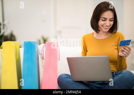 Bonne jeune femme shopping à la maison Banque D'Images