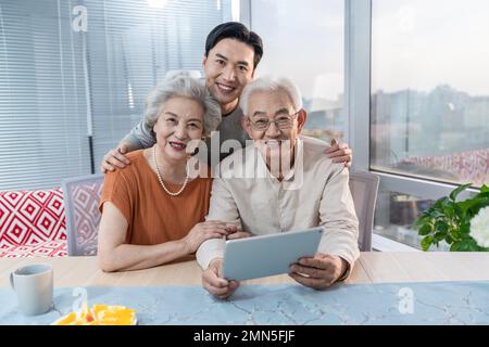 Une famille heureuse utilise des tablettes électroniques Banque D'Images