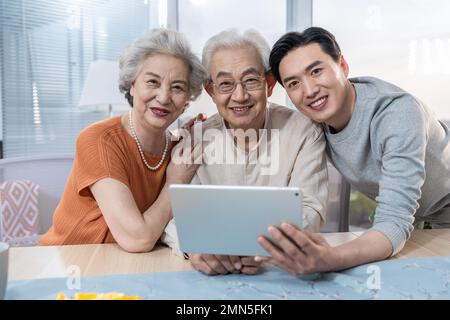 Une famille heureuse utilise des tablettes électroniques Banque D'Images