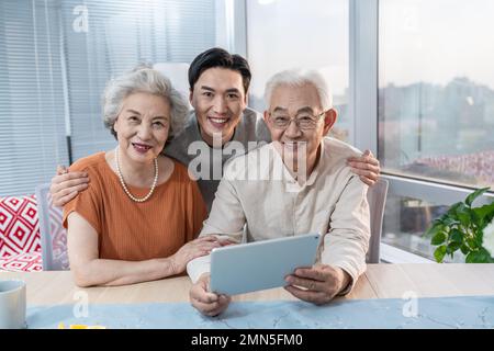 Une famille heureuse utilise des tablettes électroniques Banque D'Images