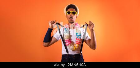 Déguisement brésilien de carnaval. Black Man with Carnival Costume Amaning Fun, isolé sur fond orange Banque D'Images