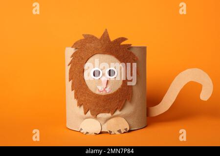 Lion jouet en rouleau de papier toilette sur fond orange Banque D'Images