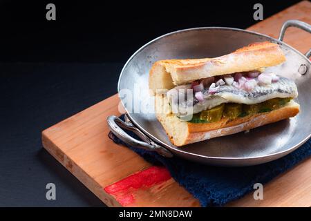 Concept alimentaire sandwich au hareng sur fond noir avec espace de copie Banque D'Images