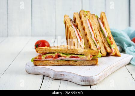 Sandwich club avec jambon, tomate, vert et fromage. Panini grillé Banque D'Images