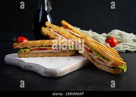 Sandwich club avec jambon, tomate, vert et fromage. Panini grillé Banque D'Images