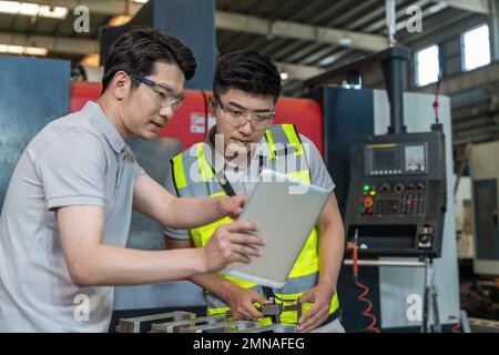 Deux ingénieurs à l'usine pour effectuer des mesures Banque D'Images