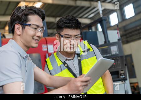 Deux ingénieurs à l'usine pour effectuer des mesures Banque D'Images