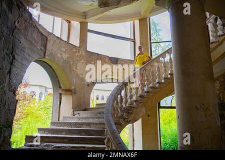 sur les marches de l'ancien escalier est une fille en jaune Banque D'Images