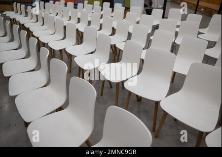 Vider les chaises en plastique blanc dans une salle de conférence. Banque D'Images