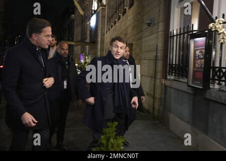 Le président français Emmanuel Macron, à droite, et le Premier ministre néerlandais Mark Rutte, à gauche, entrent dans un restaurant indonésien à la Haye, aux pays-Bas, le lundi 30 janvier 2023. (AP photo/Peter Dejong, Pool) pays-bas hors - belgique hors Banque D'Images