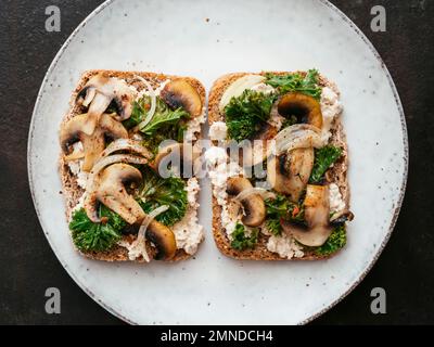 Ricotta végétalien maison, champignons et Kale sur le pain grillé Banque D'Images