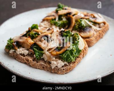 Ricotta végétalien maison, champignons et Kale sur le pain grillé Banque D'Images