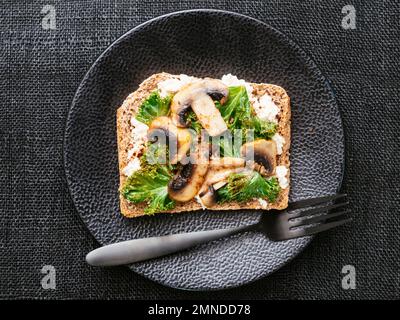 Ricotta végétalien maison, champignons et Kale sur le pain grillé Banque D'Images