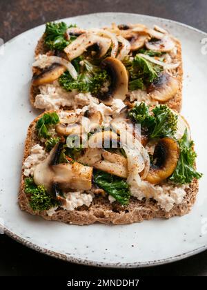 Ricotta végétalien maison, champignons et Kale sur le pain grillé Banque D'Images