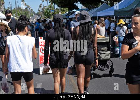 Deux femmes font du sport sur de longues tresses dans un marché agricole à Los Angeles, Californie, États-Unis. Banque D'Images