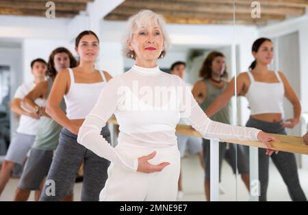 Femme âgée faisant du ballet à barre Banque D'Images