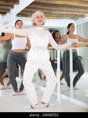 Femme âgée faisant du ballet à barre Banque D'Images