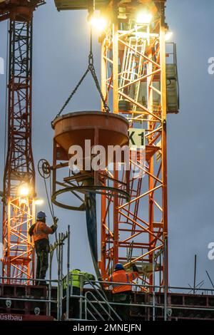 Travaux de béton, au crépuscule, sur un grand chantier de construction d'un complexe résidentiel et commercial, NRW, Allemagne, Banque D'Images