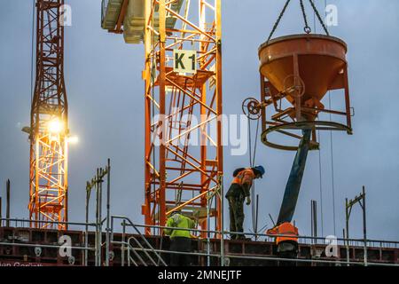 Travaux de béton, au crépuscule, sur un grand chantier de construction d'un complexe résidentiel et commercial, NRW, Allemagne, Banque D'Images