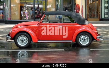 Un cabriolet VW Beetle rouge se dresse sur le Kurfuerstendamm baigné de pluie à Berlin, en Allemagne Banque D'Images