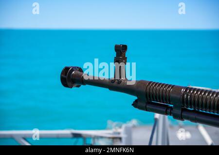 Image couleur d'une mitrailleuse automatique sur le pont d'un navire militaire, en mer. Banque D'Images