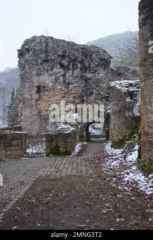 Falkenstein, Allemagne - 31 janvier 2021: Passerelle avec le château de Falkenstein ruine les murs lors d'une journée froide d'hiver dans le Rhienland Pfalz, Allemagne. Banque D'Images