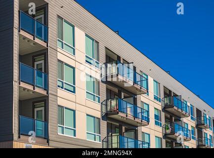 Immeubles modernes d'appartements par temps ensoleillé avec un ciel bleu. Façade d'un immeuble moderne avec balcons. Nouveau bloc de vie élégant multiétages Banque D'Images