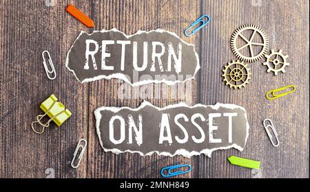 Espace de travail de bureau à la maison avec clavier, presse-papiers et stylo avec retour de texte SUR LES ACTIFS sur fond blanc en bois , affaires Banque D'Images