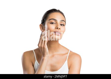 Portrait d'une jeune femme appliquant de la crème pour le visage Banque D'Images