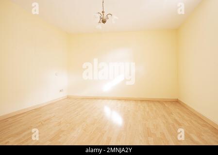 Salle de séjour vide avec murs jaune doux et un abat-jour blanc au plafond Banque D'Images