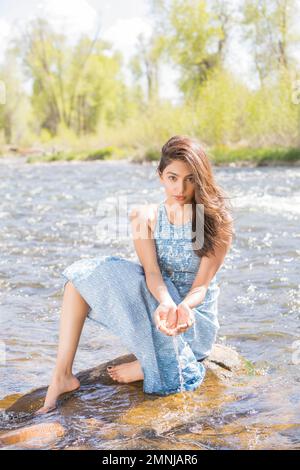 Portrait de la jeune femme en robe longue au bord de la rivière Banque D'Images