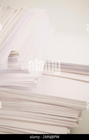 Piles de documents papier de bureau sur fond blanc. Banque D'Images