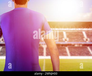 dos d'un joueur de football avec le numéro dix portant un t-shirt bleu au stade de football avec un coucher de soleil de fond Banque D'Images