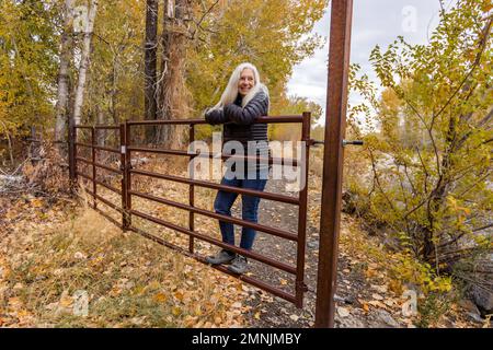 Femme blonde séchée sur la porte du ranch Banque D'Images