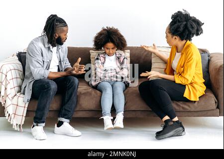Les parents afro-américains font le tri avec leur fille d'âge préscolaire, hurlez à elle, les enfants rétrain leurs parents. Le concept d'abus, les difficultés dans la relation des parents avec l'enfant, le conflit Banque D'Images