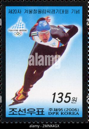 Timbre-poste nord-coréen commémorant les Jeux olympiques d'hiver de Turin en 2006, représentant un patineur de vitesse en action. Banque D'Images