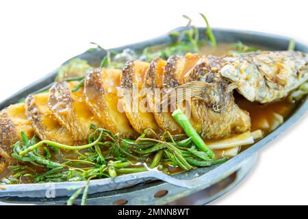 Découpe de poisson en forme de tête d'épice frite dans la soupe épicée sur blanc isolé. Banque D'Images