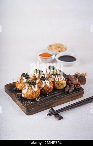 Le takoyaki est une cuisine de rue japonaise contenant du pieuvre, de la saucisse ou du fromage. garnir d'algues et de katsuobushi Banque D'Images