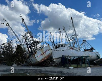 Les photos montrent des bateaux à crevettes endommagés et des débris à la suite de l'ouragan Ian à fort Myers. L'ouragan Ian a quitté cette marina de fort Myers détruite, avec des bateaux qui volait autour et des jetées en pulvérisation près d'un pont vers la plage de fort Myers. Banque D'Images